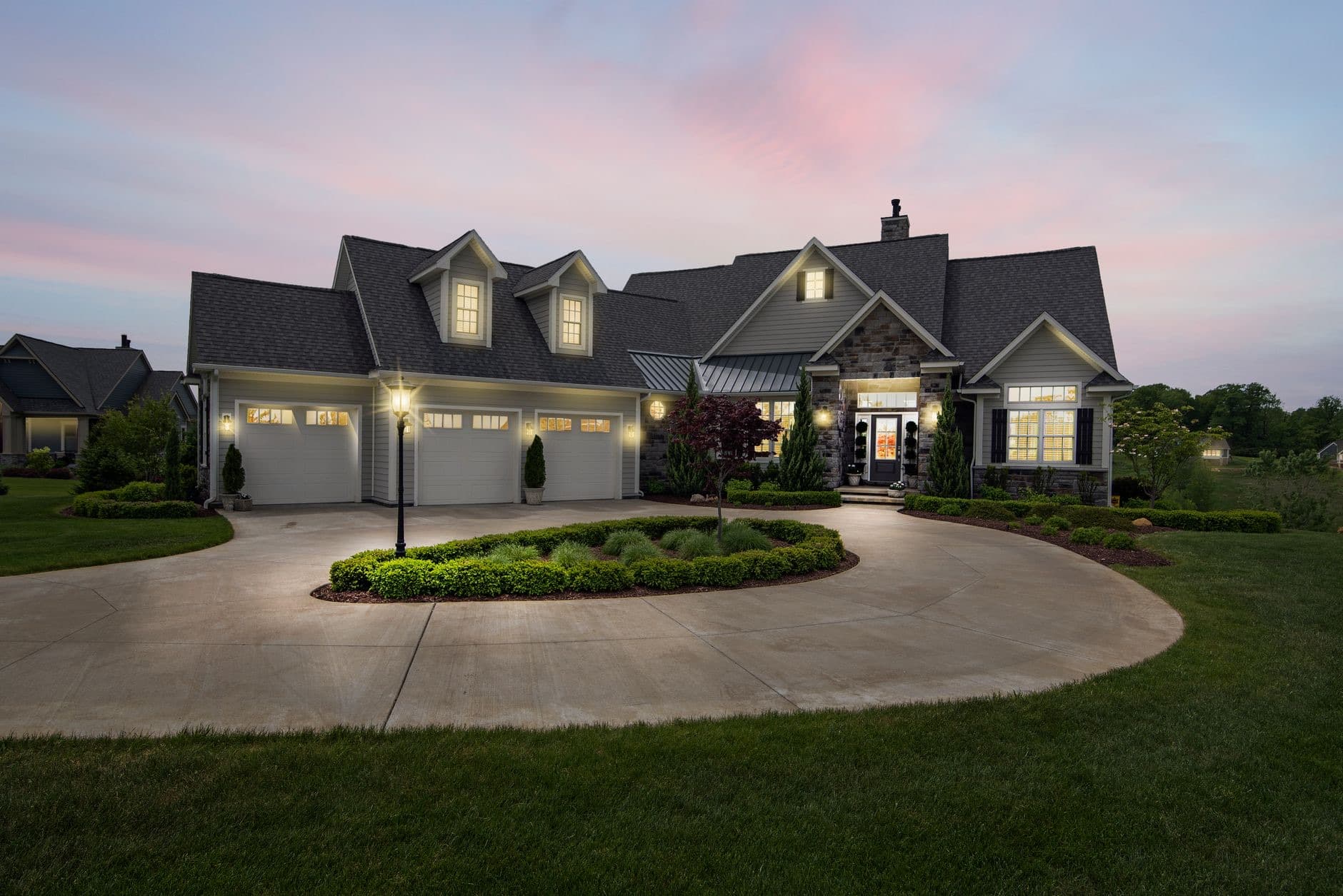 A single-family home at dusk with its lights on