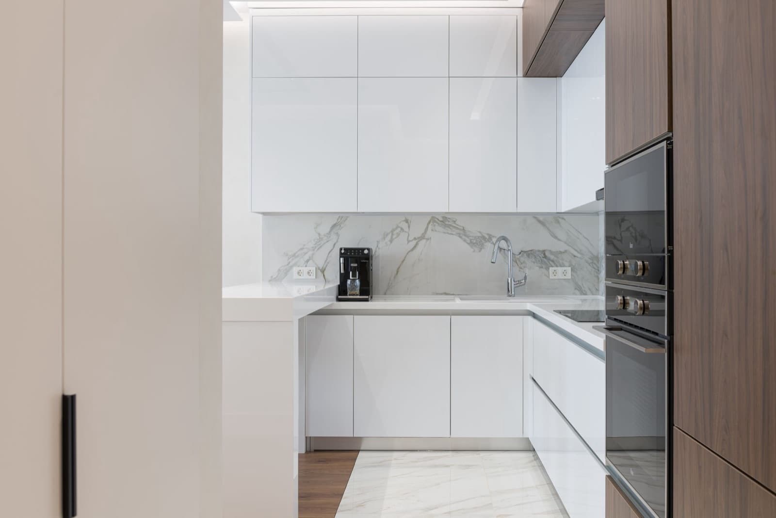 A remodeled kitchen with white stone countertops