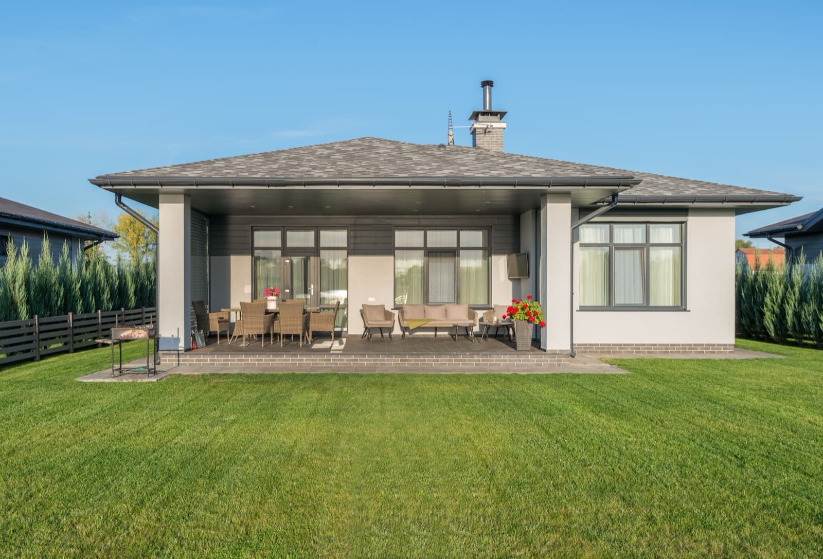 A single-story home with a covered patio and green lawn